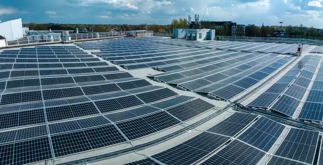 Rows of solar panels covering a large flat commercial rooftop