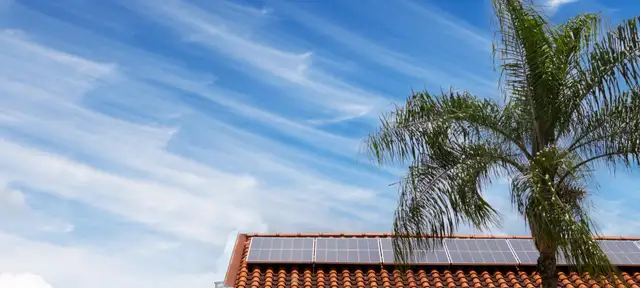 Solar panels on a tile roof under a blue sky
